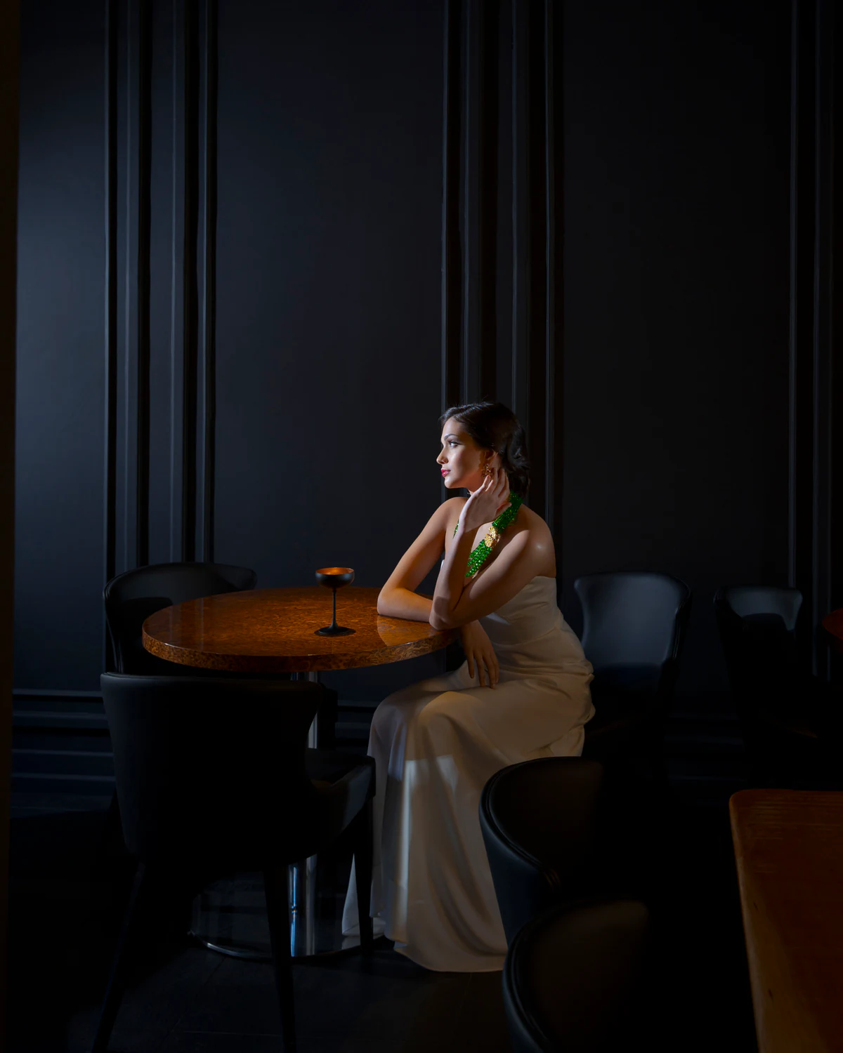 A woman sitting alone at a table in a dark room