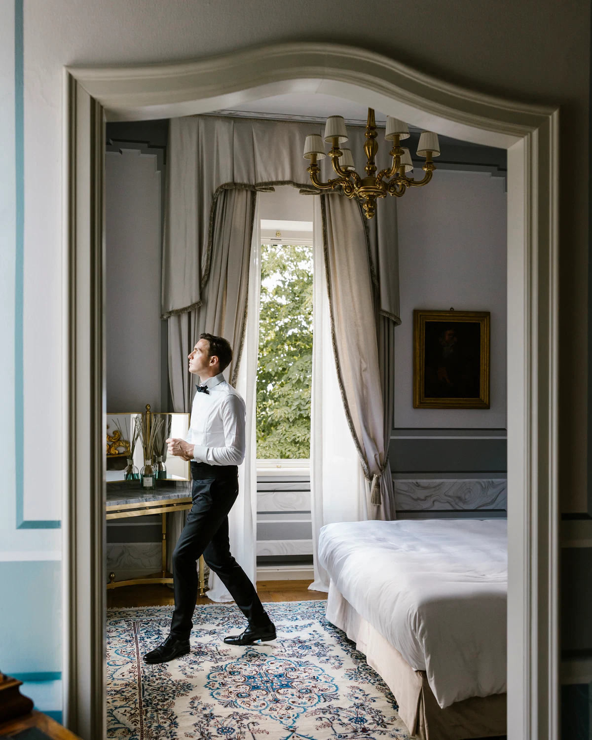 The groom crossing the doorway of a period bedroom