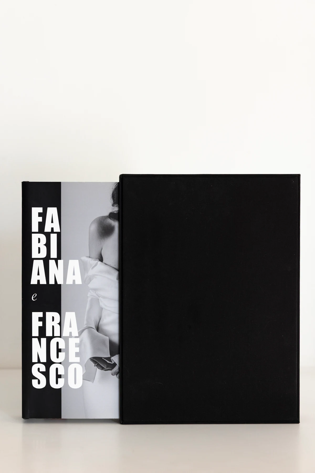 The Editorial Album, closed, half out of its slipcase, with Fabiana and Francesco on the cover