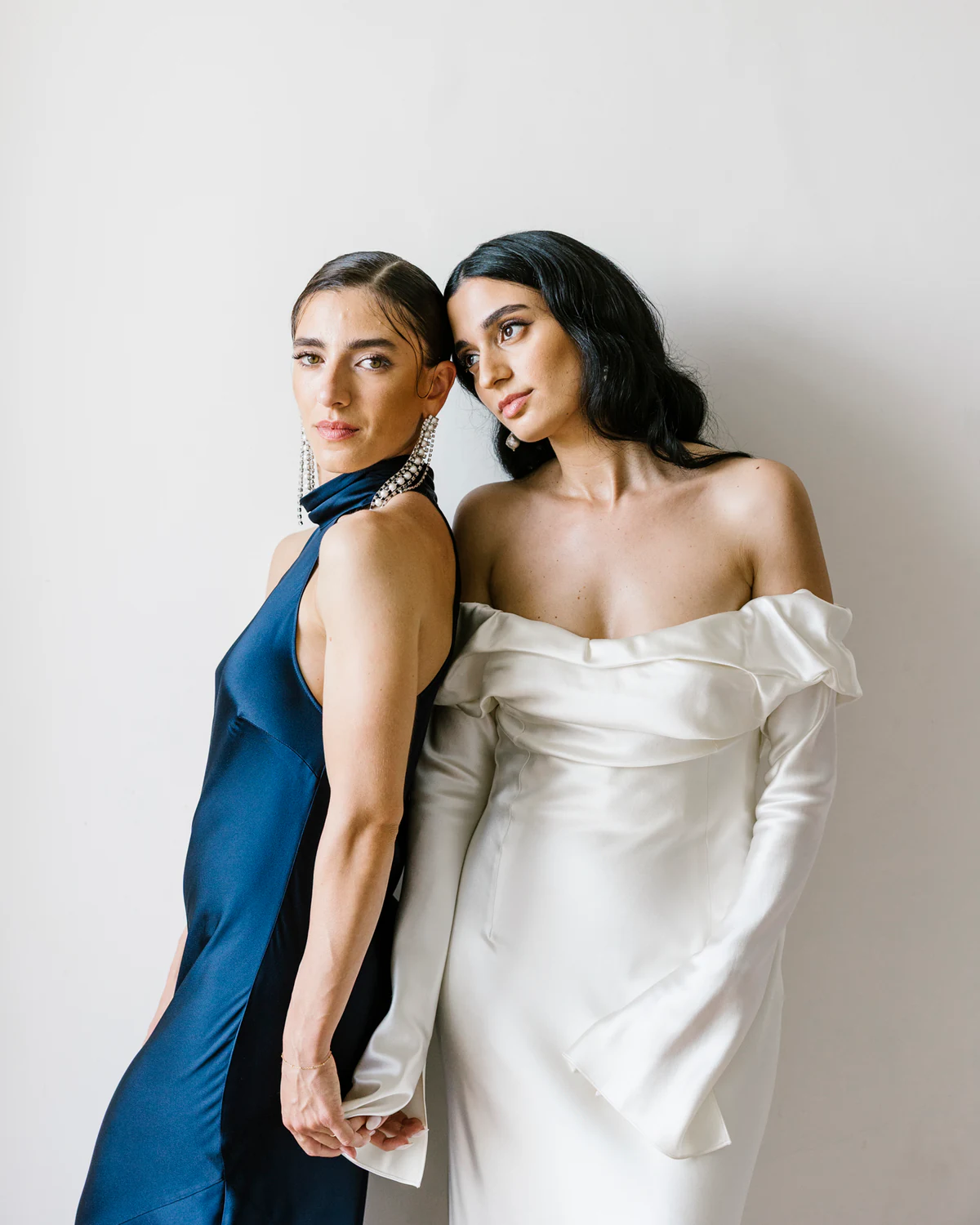 The bride and a friend in a blue dress, cheek to cheek