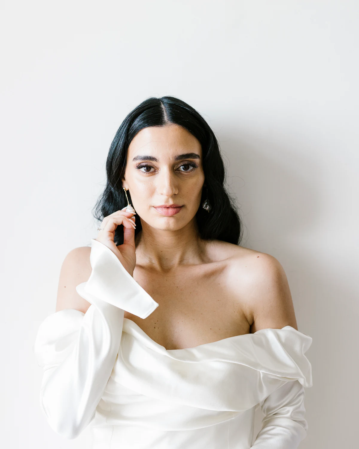 Portrait of the bride against a white wall