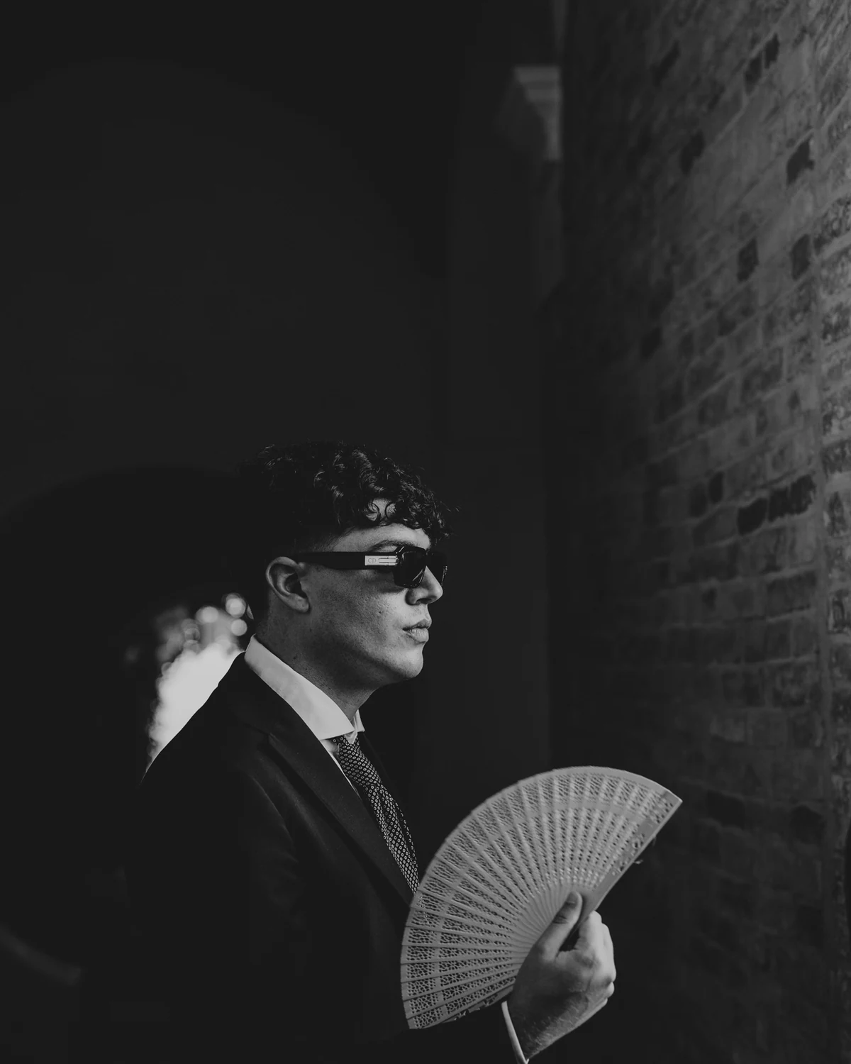 A guest in sunglasses with a fan, in the shade