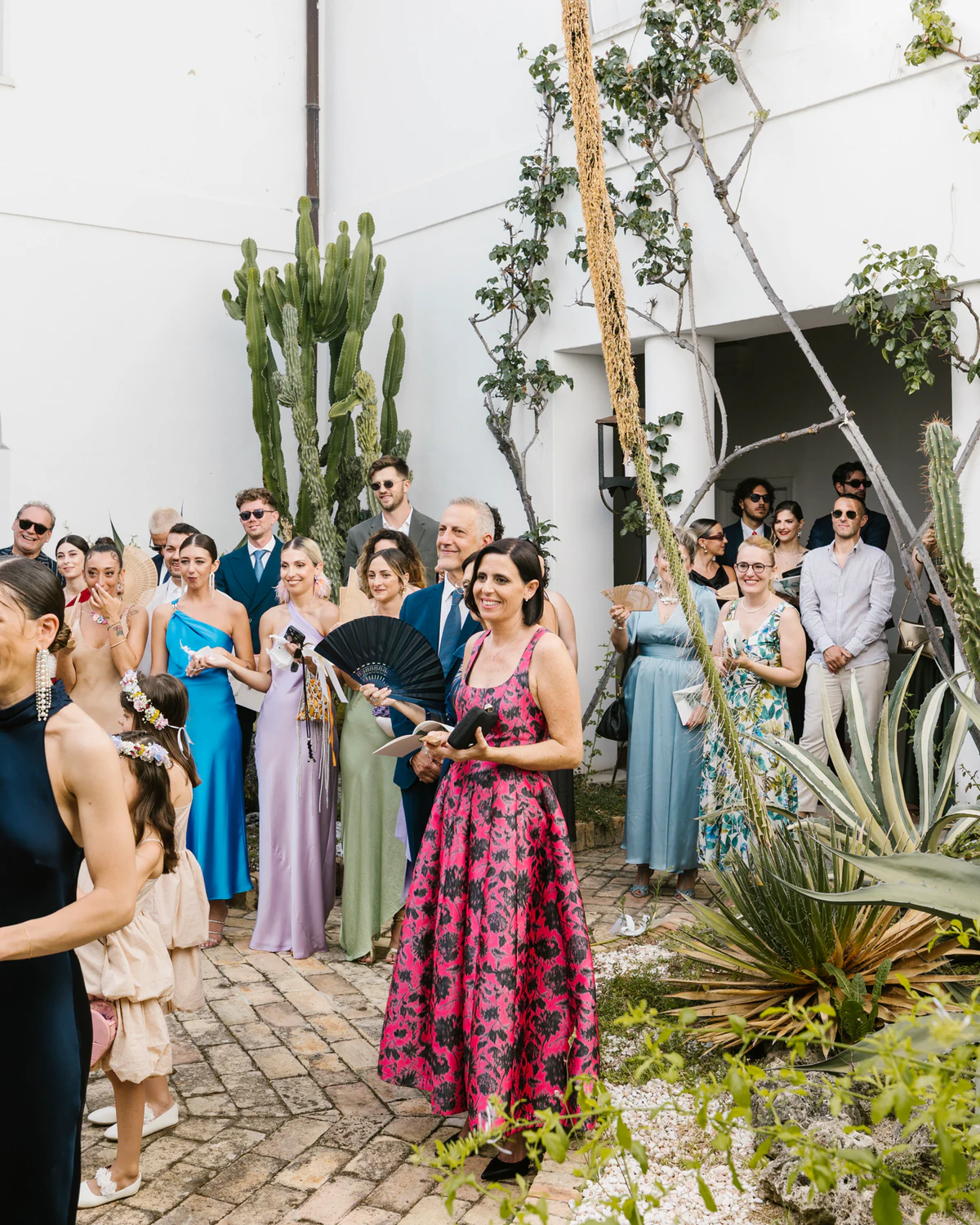 Guests gathered in the courtyard among cacti and flowers
