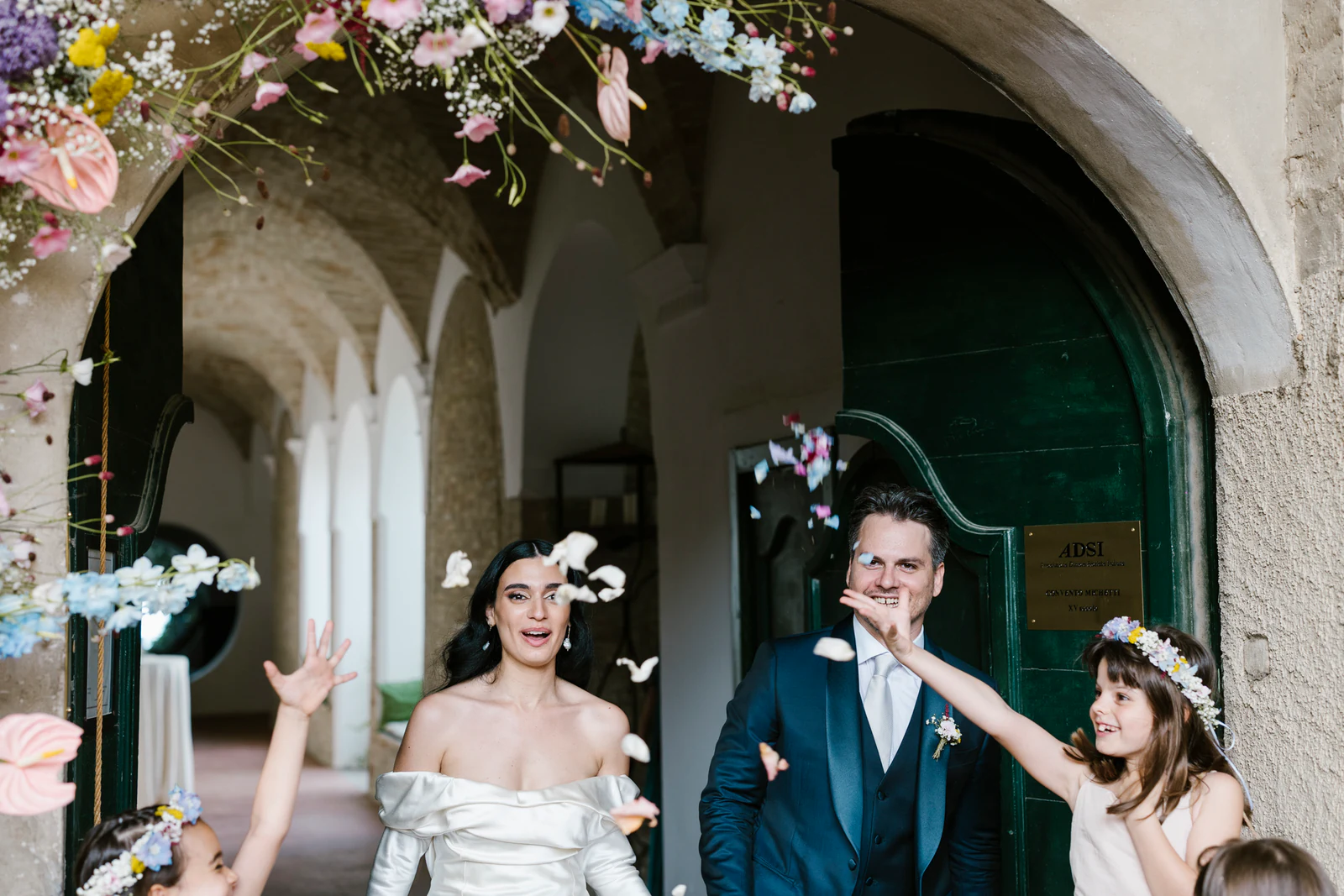 The couple leaving the cloister under a shower of petals