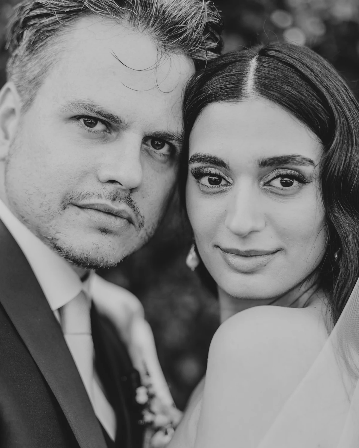 The couple cheek to cheek, looking into the camera