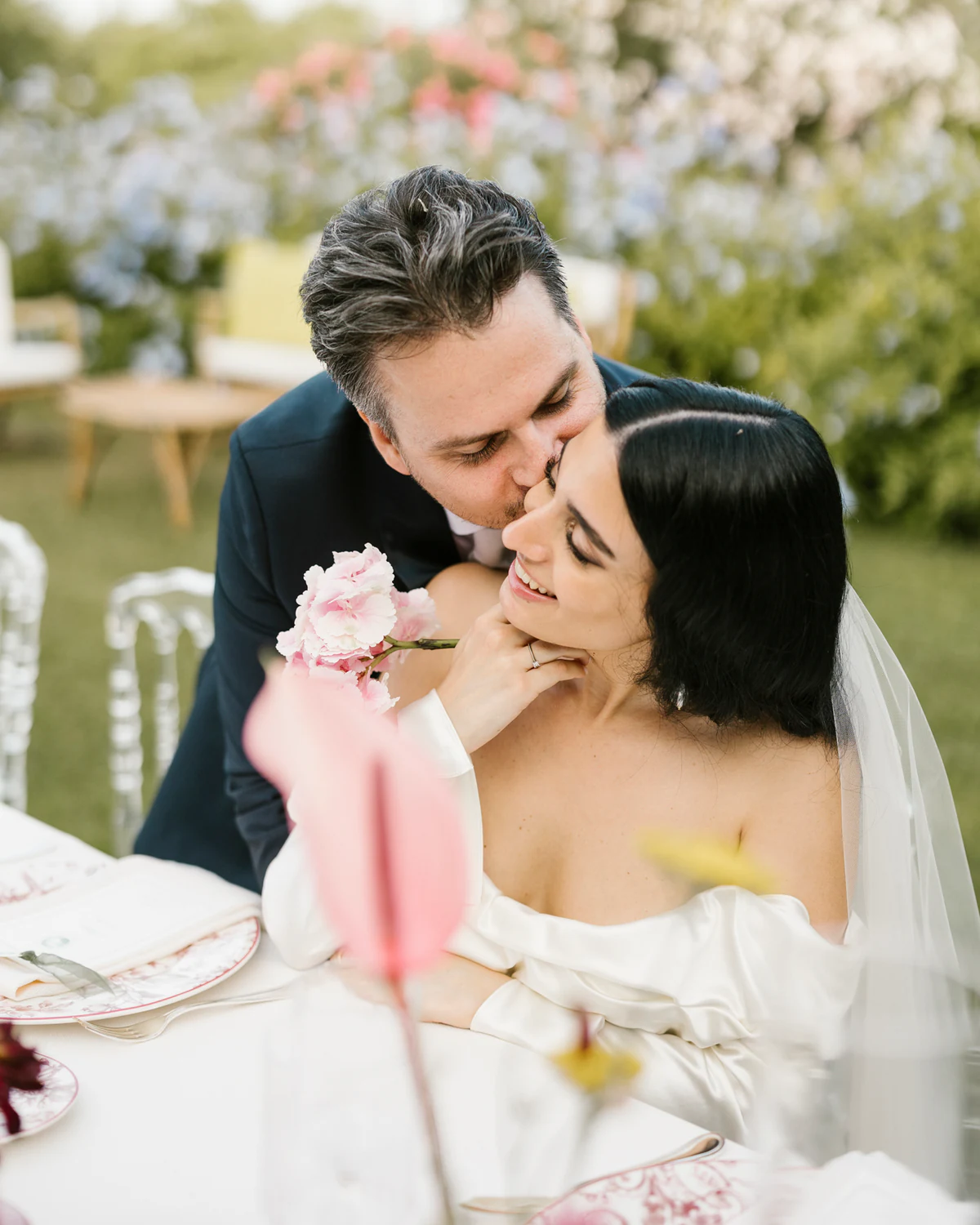 The groom kissing the bride at the table