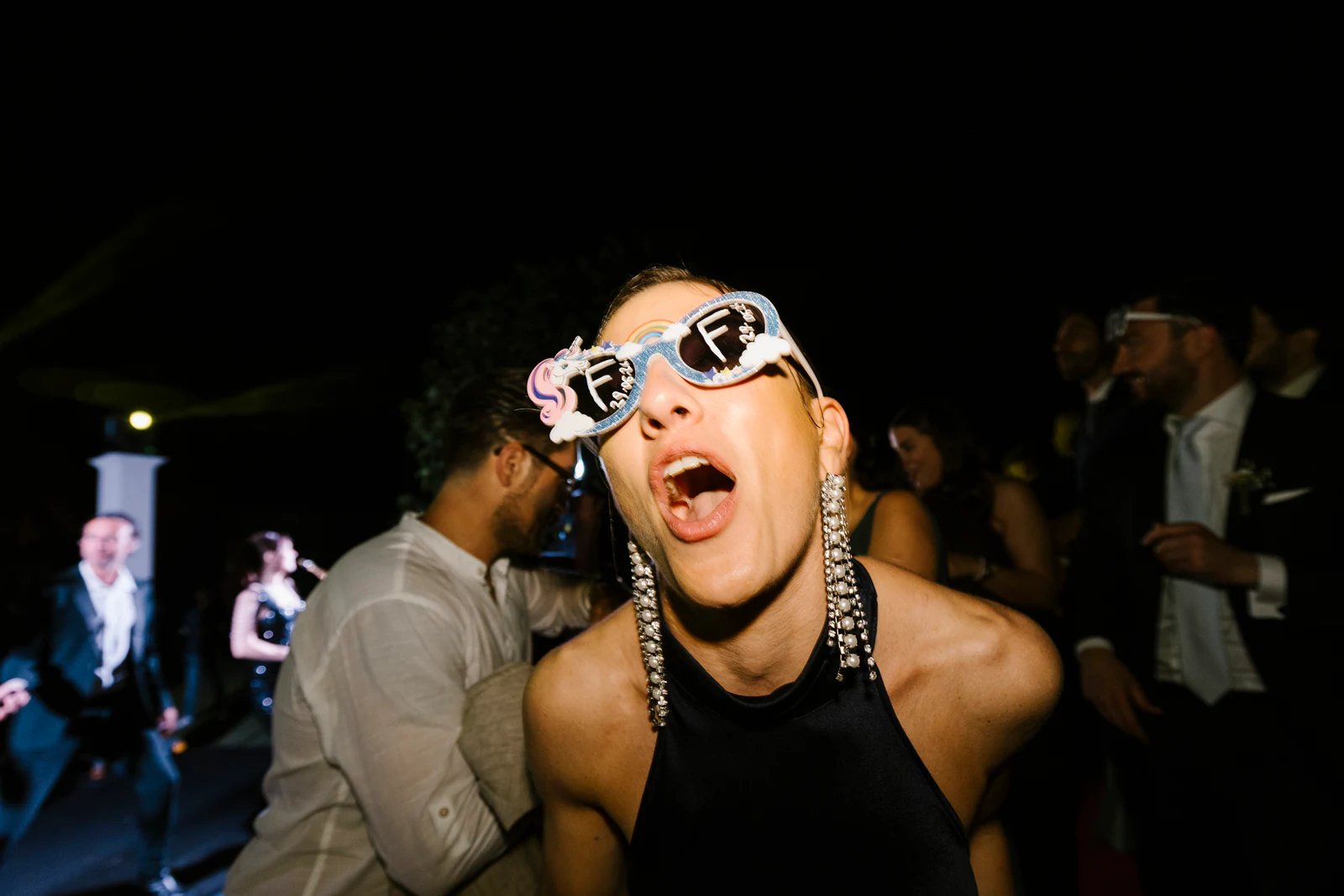 A guest in novelty glasses singing at the top of her voice