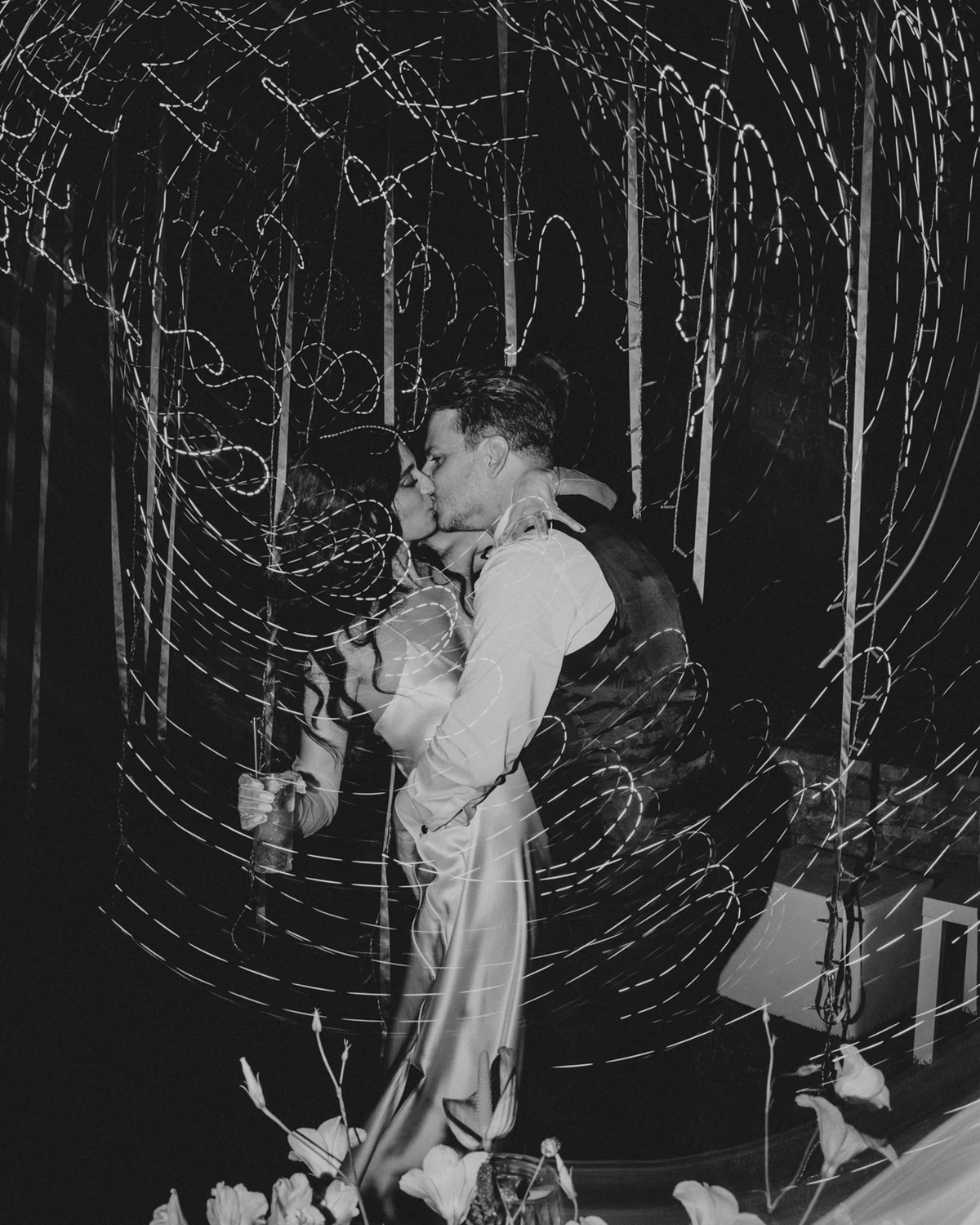 The couple kissing under the lights at the end of the night