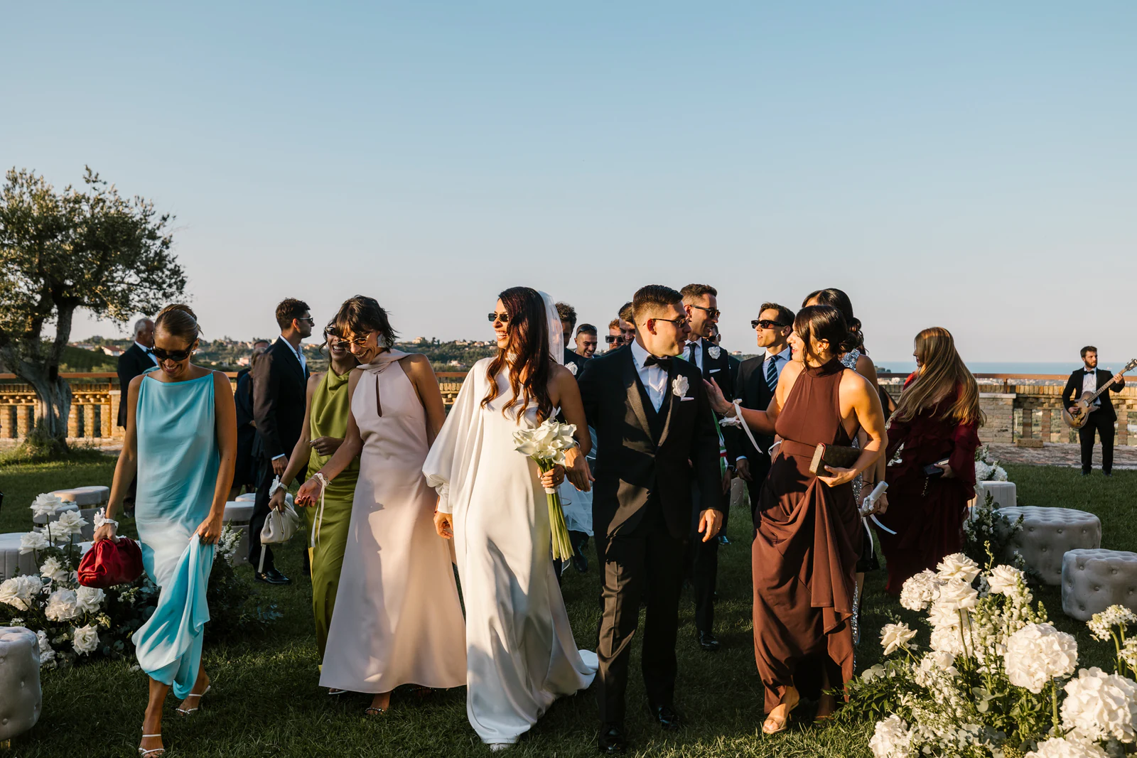 The couple walking through the garden with their guests