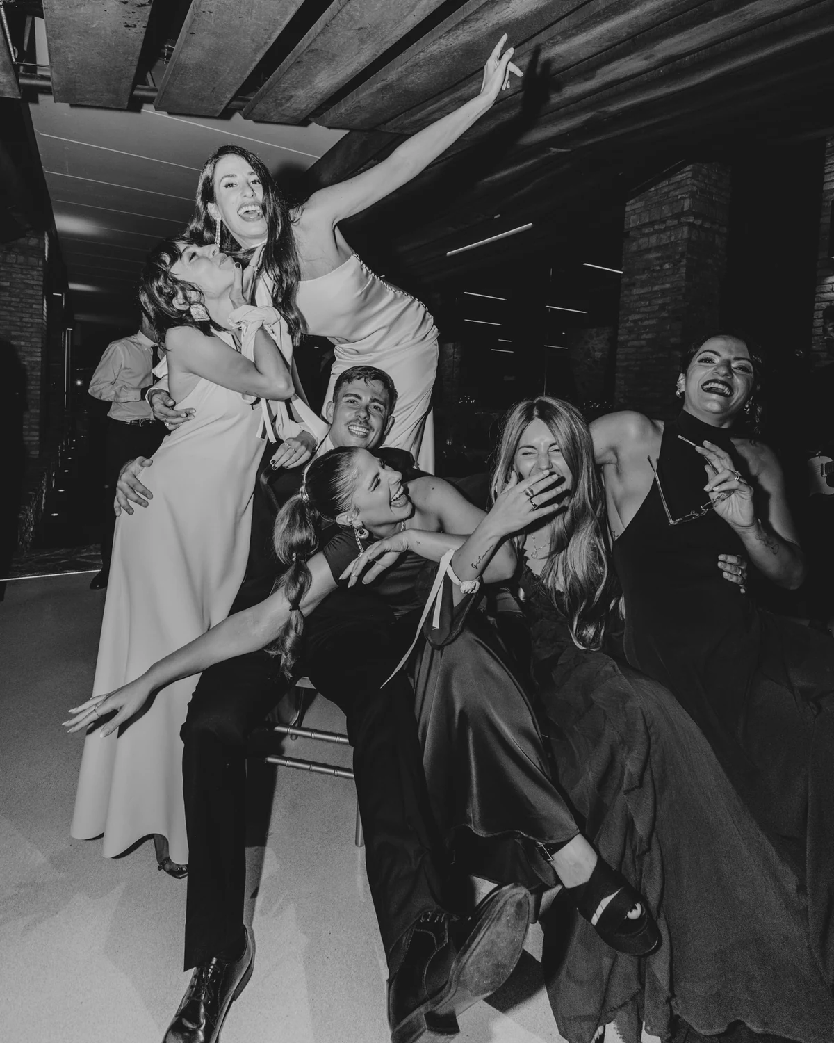 The bride lifted up by her friends on the dance floor