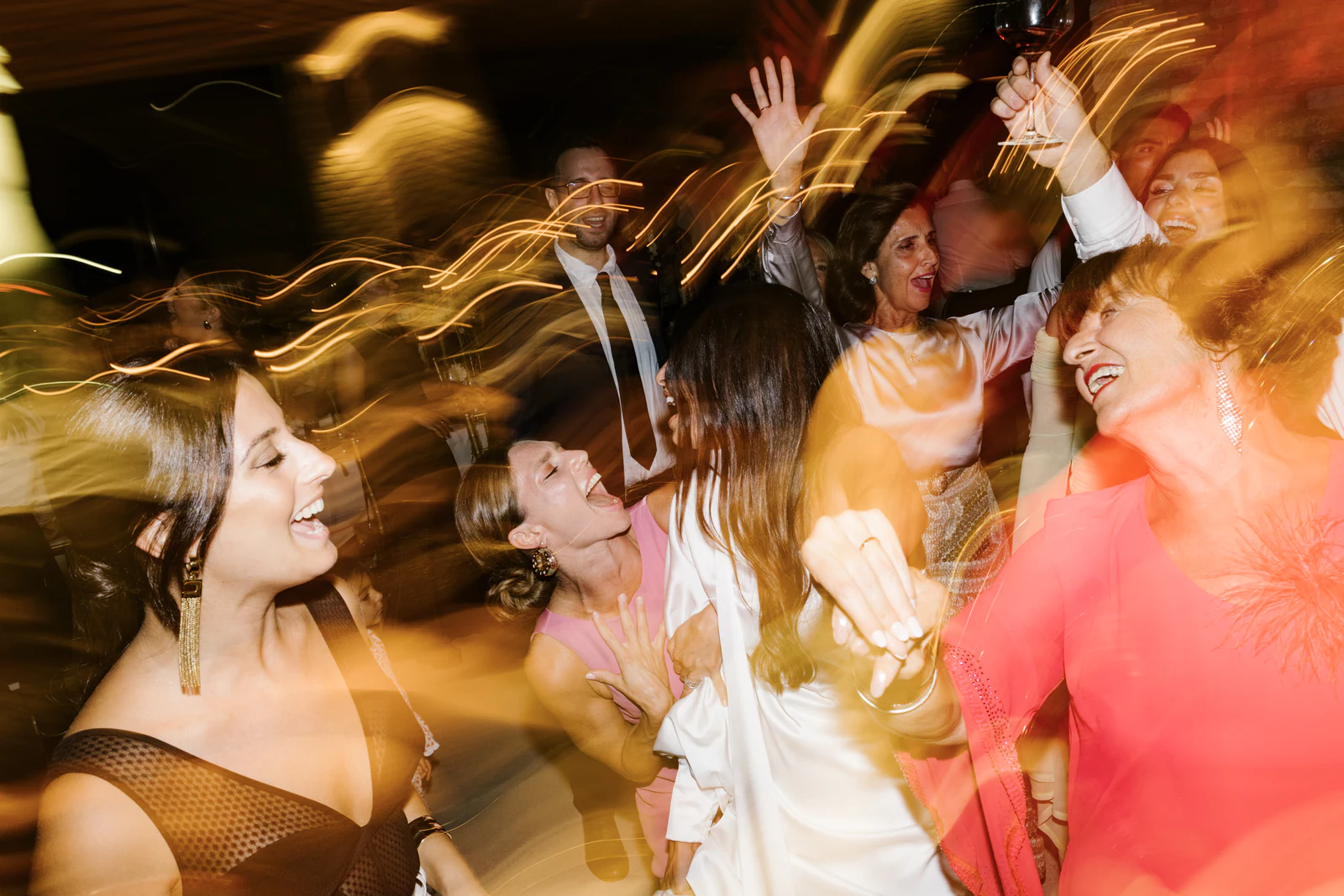 The bride and her friends laughing on the dance floor