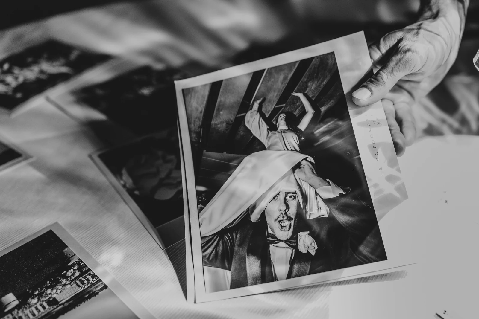 Instant prints from the party, held in a hand