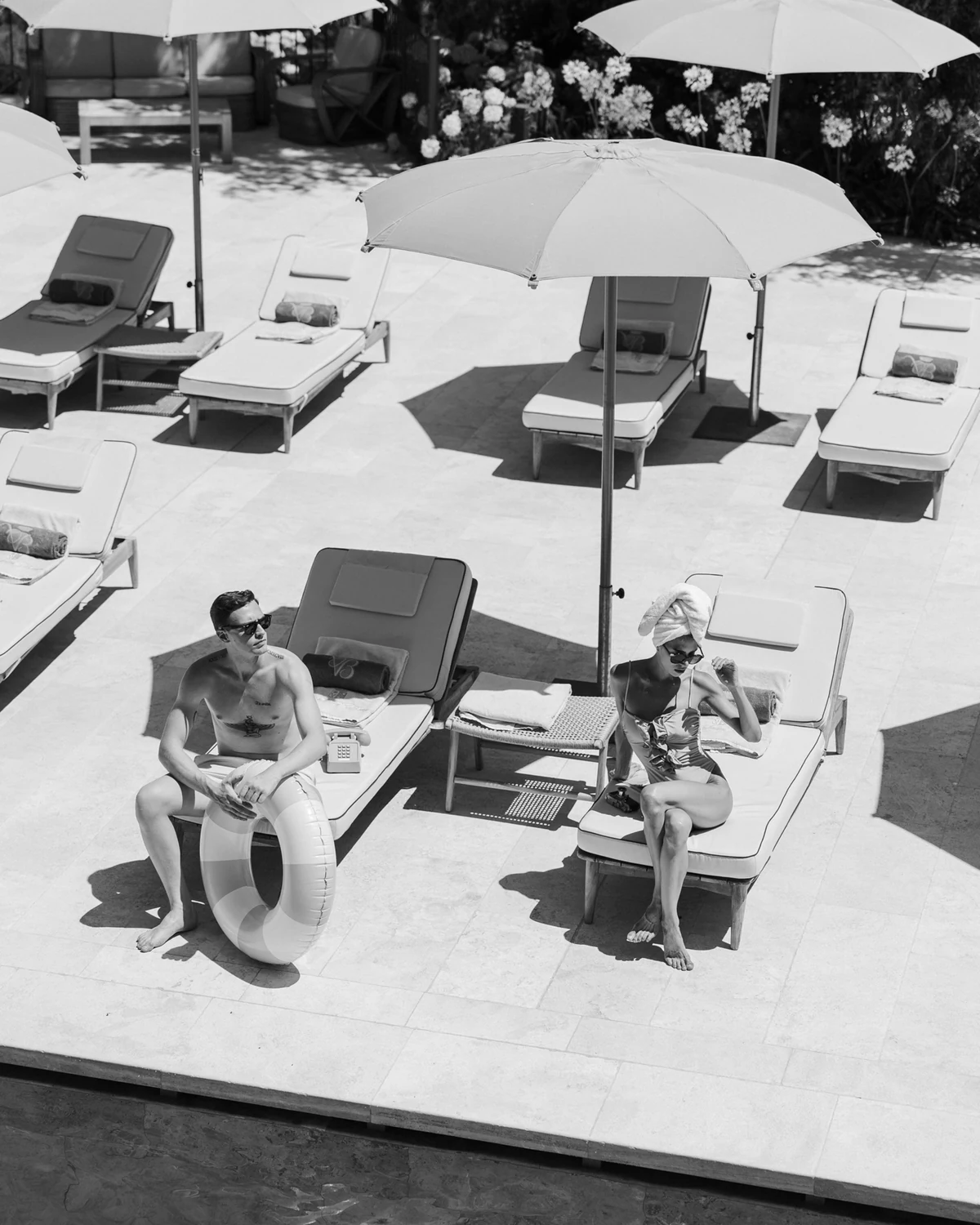 The couple on sun loungers by the pool, seen from above