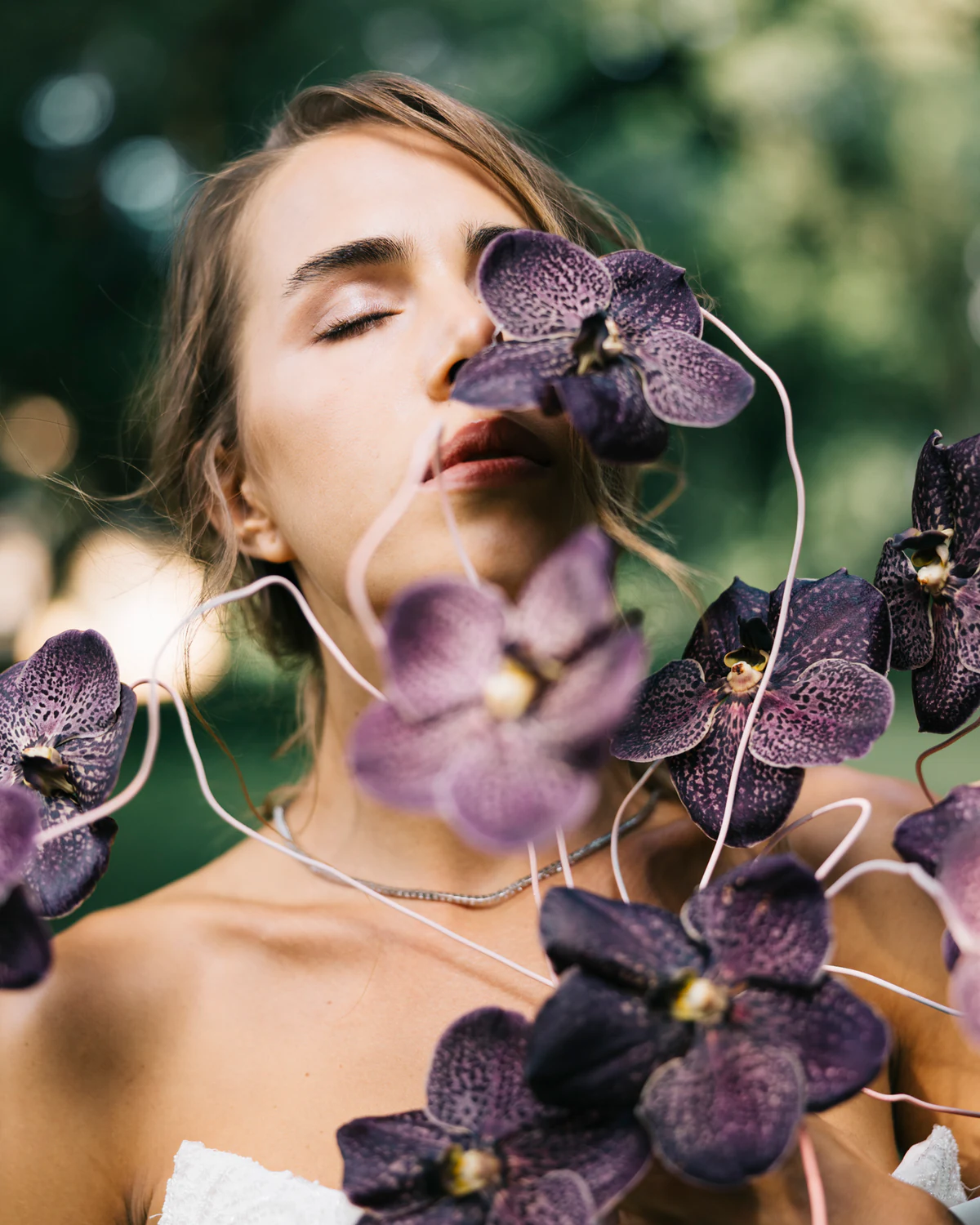 The bride with her eyes closed among purple orchids