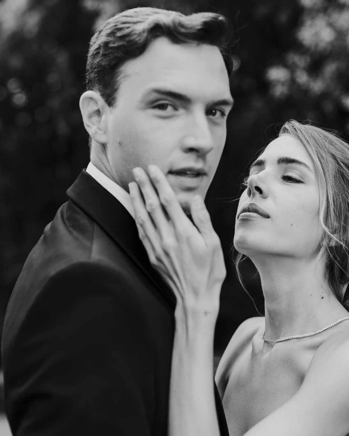 The couple cheek to cheek, his hand on her face