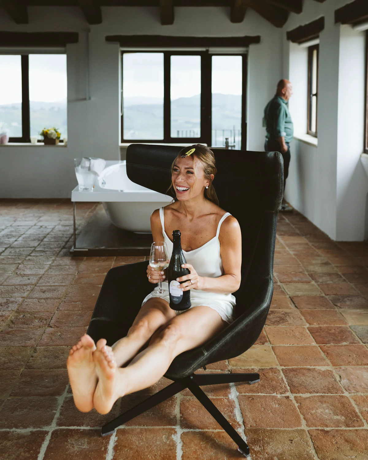 The bride relaxing in an armchair with a glass of champagne