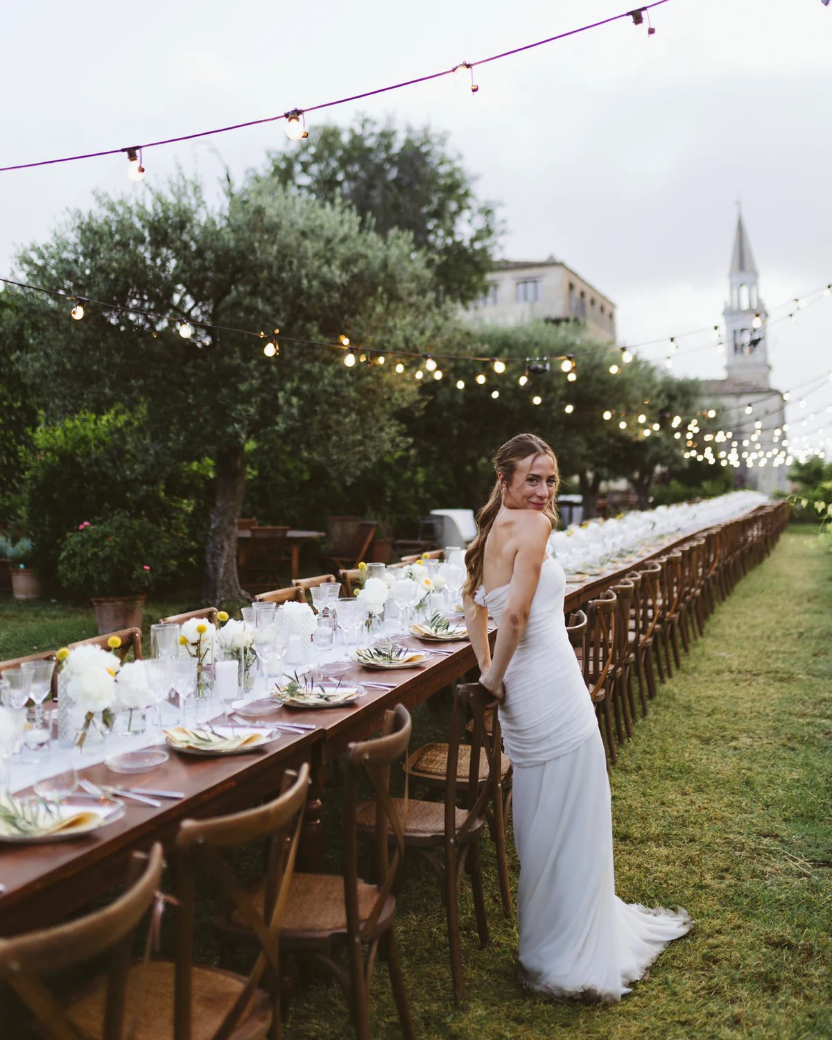 The bride beside the long table set in the garden
