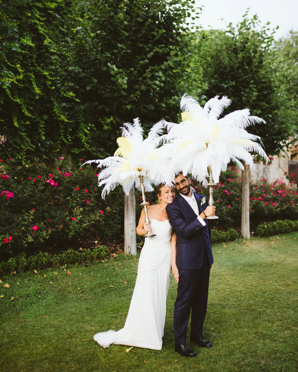 The couple kissing behind the feather fans