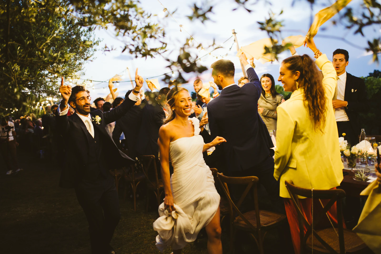 The couple arriving at dinner among cheering guests