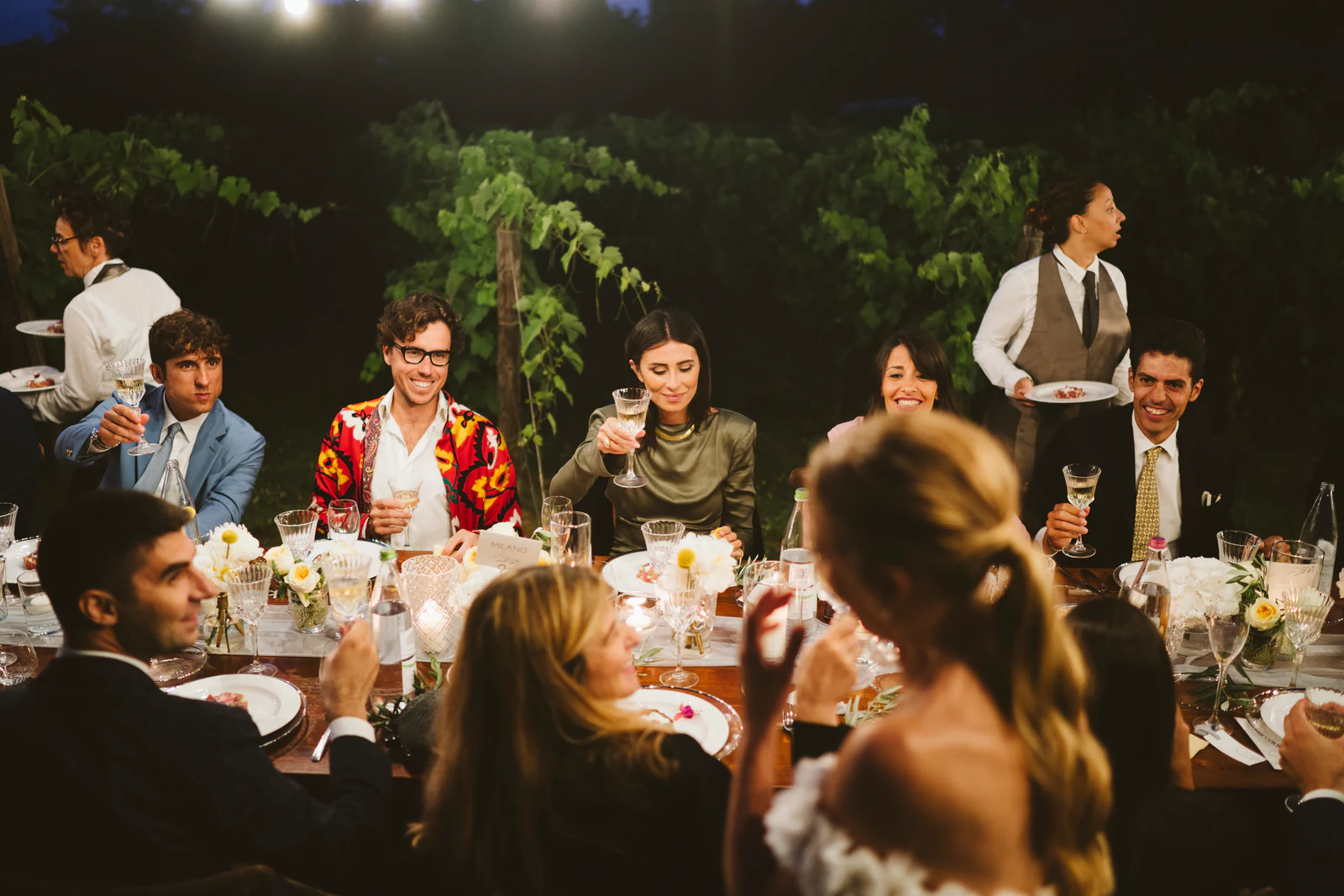 Guests laughing at the table at night