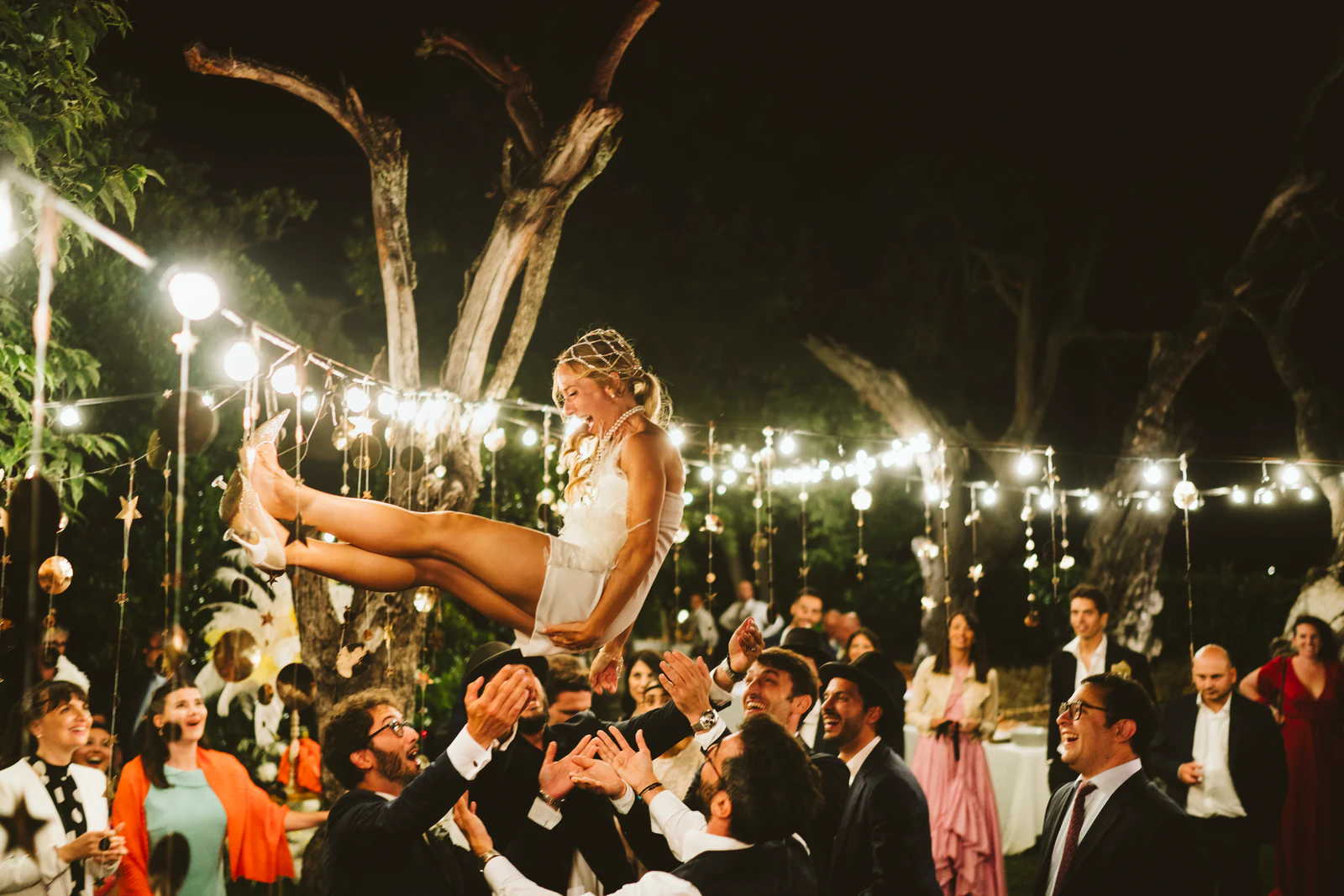The bride lifted into the air by the guests
